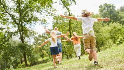 Family exploring nature during the summer months referencing a blog about a Montessori School digital detox for summer to keep balance in kids days.