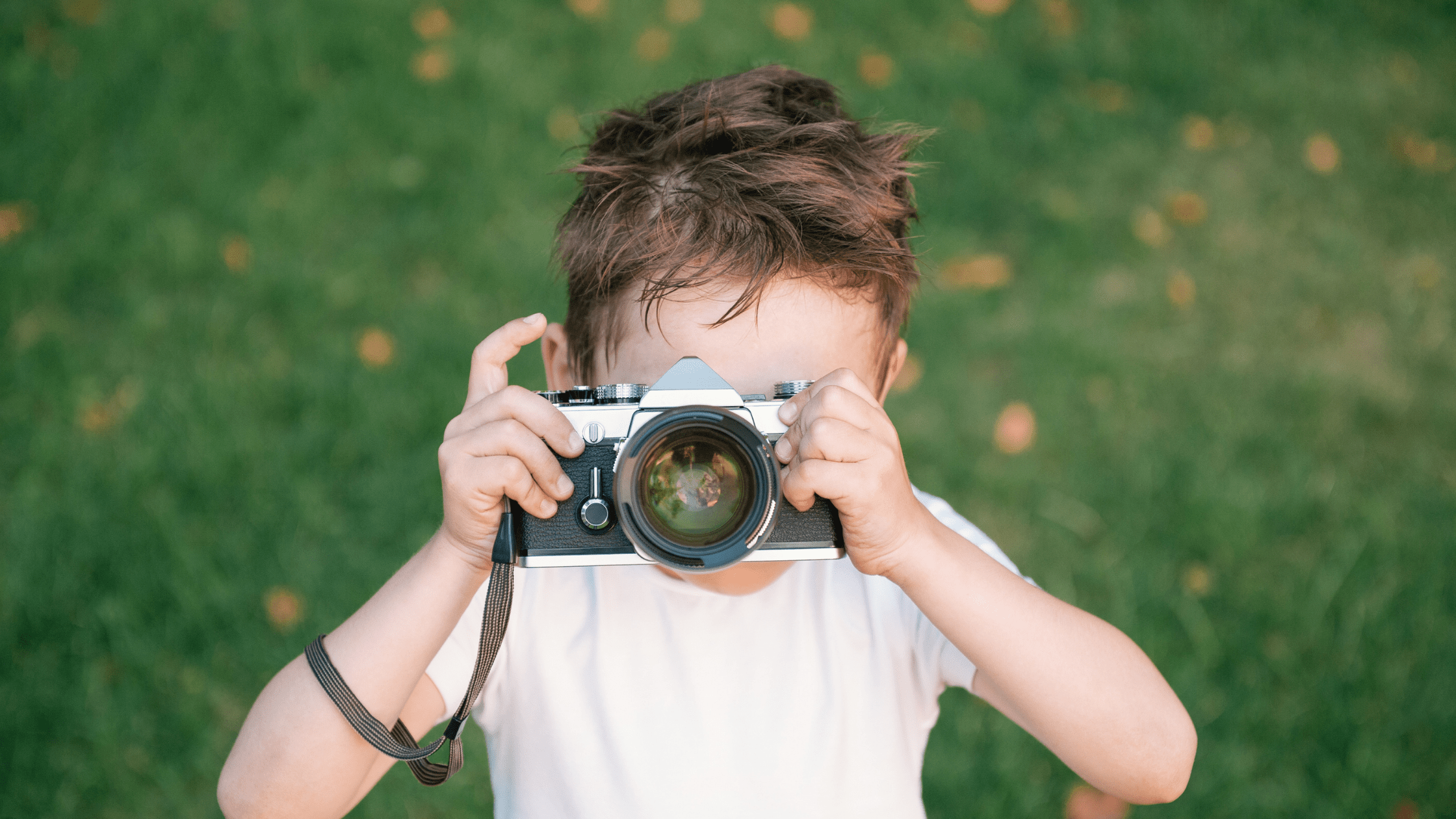 Boy using a vintage camera for documenting Montessori Family Summer Memories